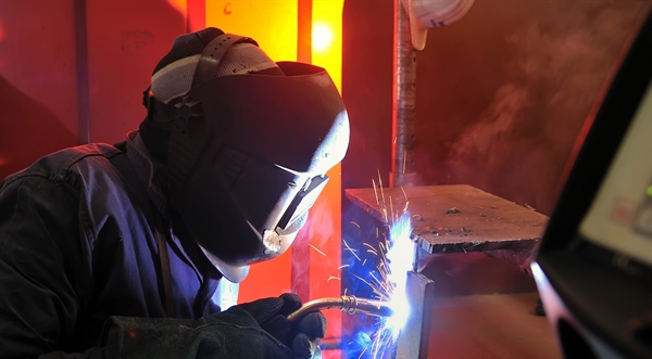Welder working with sparks in industrial setting