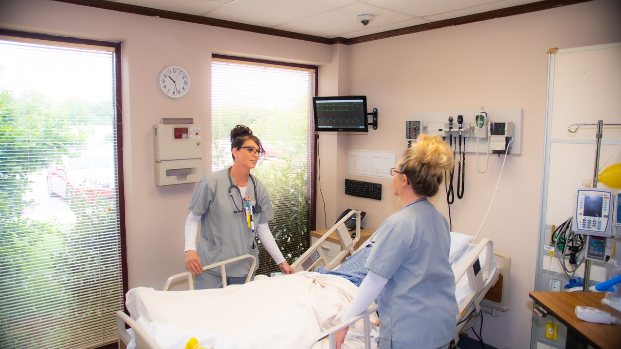 Nurses attending patient in modern hospital room