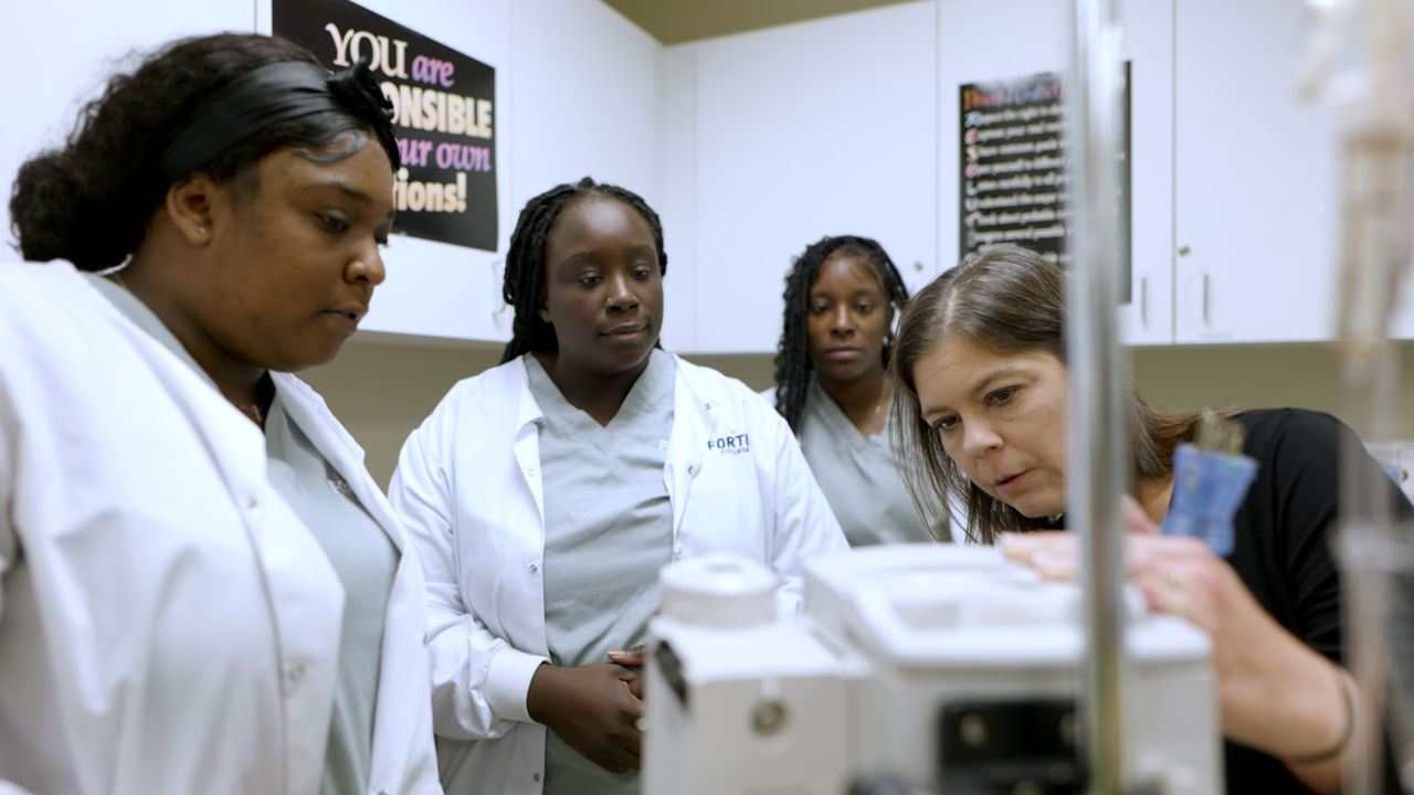 Medical students observe equipment demonstration in lab setting