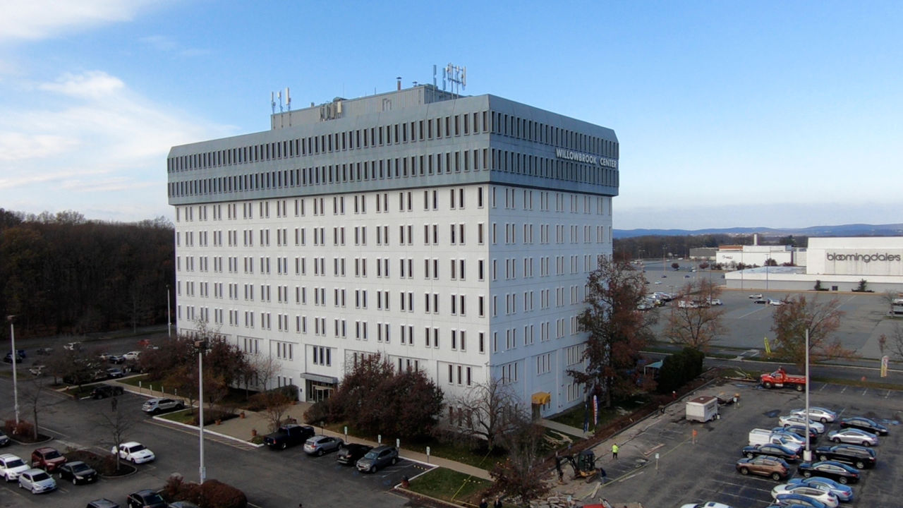 Large office building with parking lot on clear day