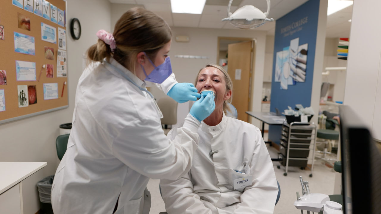 Dental professional examines patient in clinical setting