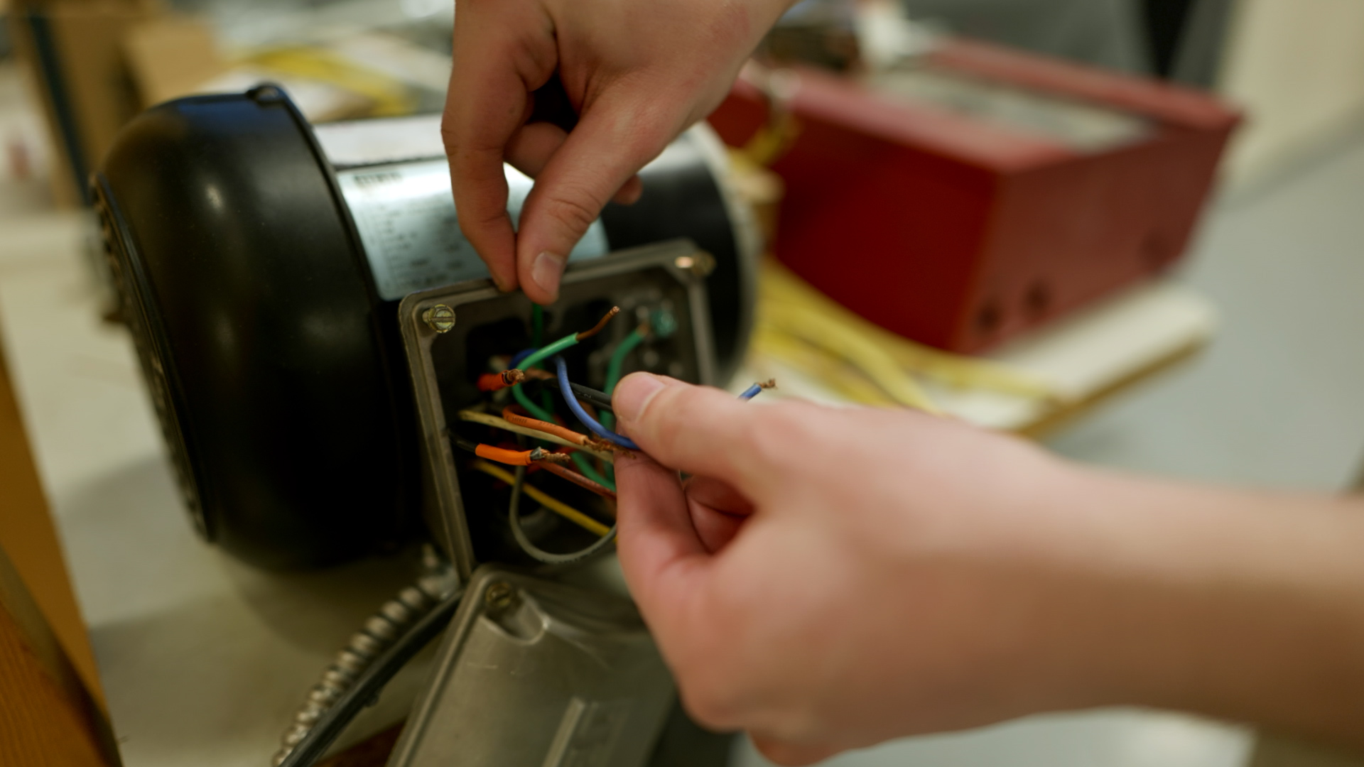 Technician Wiring Electrical Motor in Workshop Setting
